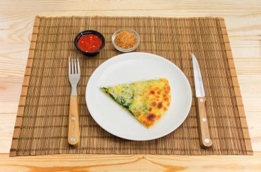 Khachapuri çanak, çatal ve bıçak ve baharat bambu yer mat ahşap renkli rustik masa lambası üzerinde dilim