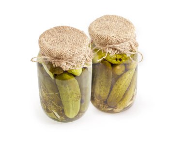 Salatalık ile baharat beyaz bir arka plan üzerinde iki cam kavanozlarda konserve