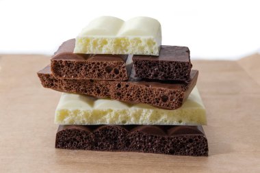 Karanlık parçaları, sütlü ve beyaz çikolata yakın çekim seçici odak kağıt sarma gazlı