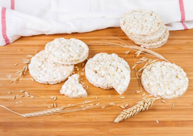 Kuru yuvarlak kabarık kahverengi pirinç eklenmesi ile yapılan crispbreads arasında diğer hububat farklı kepekli tahıllar ve kulakları bir bambu ahşap yüzeye