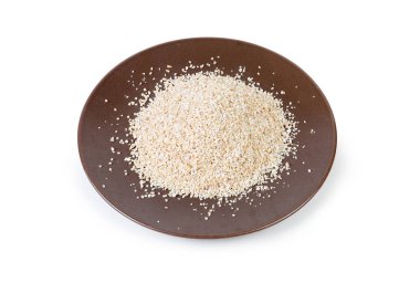 Pişmemiş fine-zemin arpa kabuğu çıkarılmış tane kahverengi seramik tabak beyaz bir arka plan üzerinde üzerinde