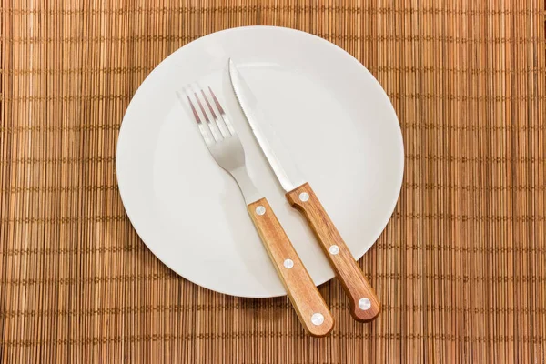 Κάτοψη Του Άδειο Πιάτο Στρογγυλό Λευκό Πιρούνι Και Μαχαίρι Ξύλινη — Φωτογραφία Αρχείου