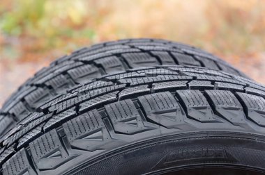 Araba lastikleri ile bulanık bir arka plan üzerinde asimetrik lastik parçası