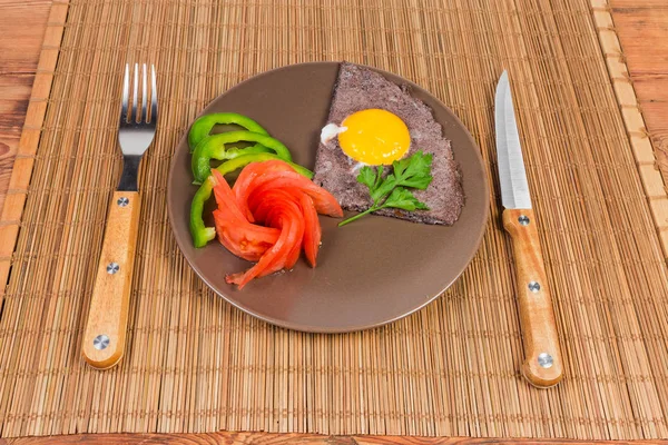 炒鸡蛋阳光的一面 用黑橄榄和未碎的蛋黄打蛋清 在菜上切蔬菜 在竹桌上的桌子上的桌子上的叉子和刀 — 图库照片
