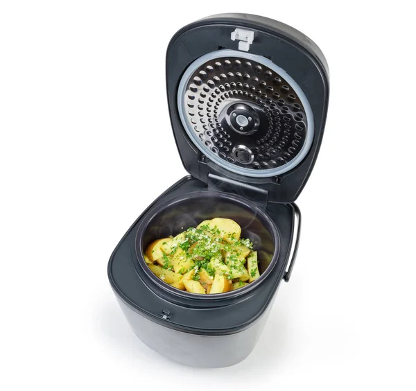 Baked potato slices sprinkled with chopped parsley and garlic in household electric multi-cooker with open lid on a white background