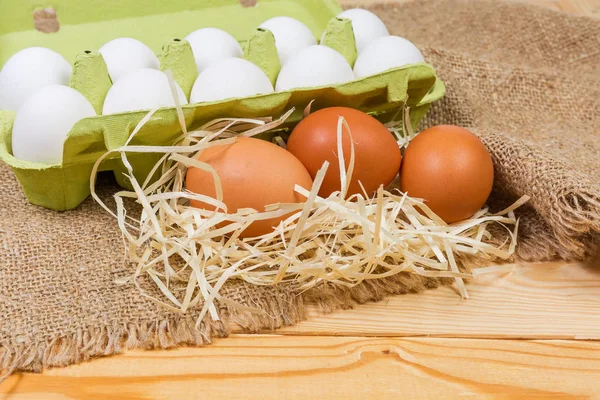 鸡蛋纸盒背景上的棕色鸡蛋 用回收的纸浆与白色的鸡蛋放在乡村的桌子上 有选择性聚焦的麻布 — 图库照片