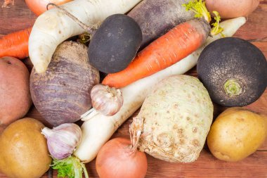Arka plan çeşitli yıkanmış değil soyulmuş pişmemiş kök sebze onların deri eski ahşap rustik masa