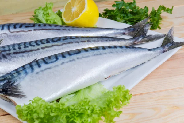 Pişmemiş başsız leşleri, uskumru, limon ve taze yeşillik yemek, seçici odak üzerinde gutted