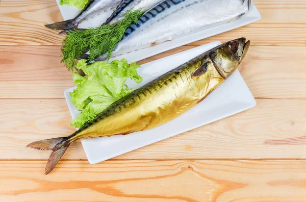 在白色盘子上的烟熏大西洋鱼 对生鱼的尸体和木制乡村的桌子上的青菜 — 图库照片