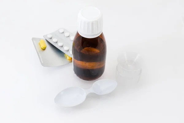 小棕色瓶与医疗混合物 水泡包装与药丸 医疗测量杯和勺子 — 图库照片