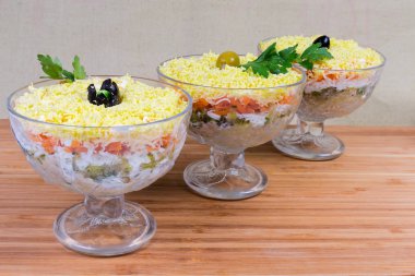 Konserve balık, rendelenmiş peynir, haşlanmış yumurta ve sebze, salata serpilir cam salata kaseleri Mimoza salata olarak adlandırılan bir ahşap yüzeye ufalanmış yumurta sarısı ile