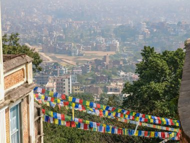 Katmandu Swayambhu tepenin üstünden. Swayambhunath ana giriş dua bayrakları ile Doğu görünümünden üzerinde bir ön plan, Nepal