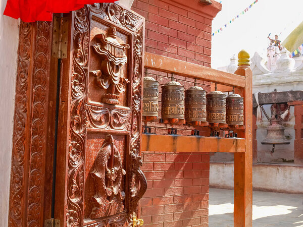 Стационарные молитвенные колеса из листового металла с тисненой мантрой в Бодханатхе, Катманду, Непал
