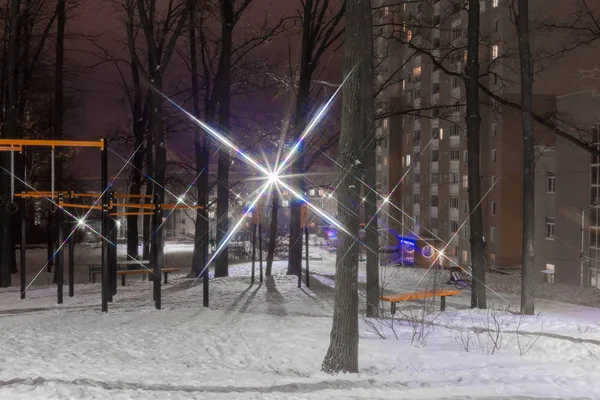 在现代多层住宅楼附近的前景上欣赏冬季照明公共公园的夜景 — 图库照片
