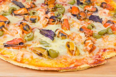 Seçici odak, deniz ürünleri ve zeytin yakın çekim ile pişmiş pizza parçası