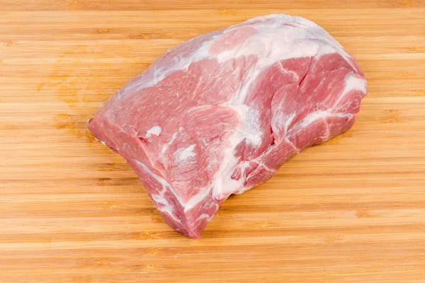 Piece of uncooked pork neck on wooden cutting board — Stock Photo, Image