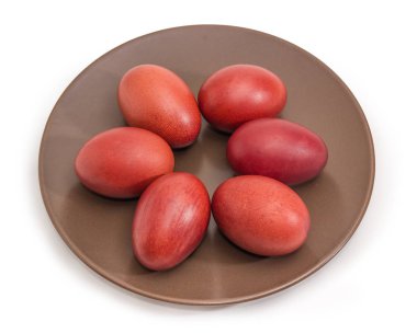 Beyaz bir arka plan üzerinde kahverengi çanak üzerinde Paskalya yortusu yumurta