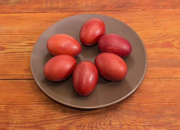 Пасхальные яйца на коричневом блюде на деревенском столе — стоковое фото