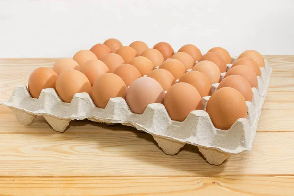 Huevos marrones en bandeja de huevo sobre mesa rústica de cerca — Foto de Stock