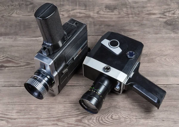 Alte mechanische und elektrische Amateurfilmkameras auf hölzerner Oberfläche — Stockfoto