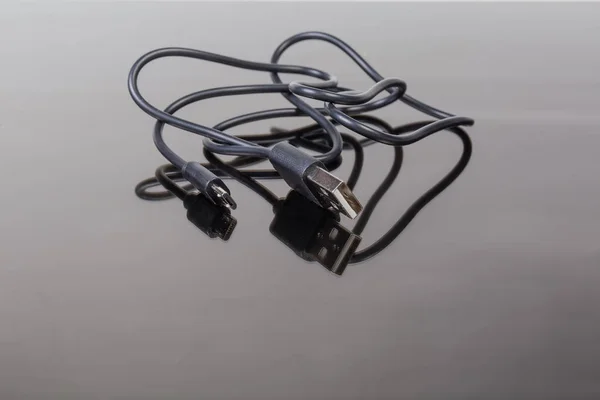 Kabel usb auf micro-usb auf dunkler reflektierender Oberfläche — Stockfoto