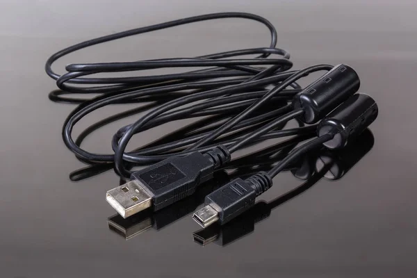 Cable USB to mini-USB on a dark reflective surface