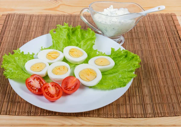 Halvorna av kokt kyckling ägg, sallad, tomat och majonnäs — Stockfoto