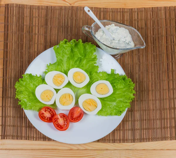 Halvorna av kokt kyckling ägg, sallad, tomat och majonnäs — Stockfoto