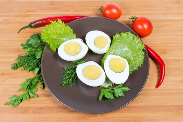 Fele főtt csirke tojás, barna edényt zöldségekkel — Stock Fotó