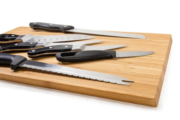 Fragmento de tabla de cortar de madera con diferentes cuchillos de cocina —  Fotos de Stock