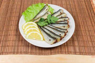 Hamsi, limon, yeşil bambu masa mat üzerinde uçan daire üzerinde füme