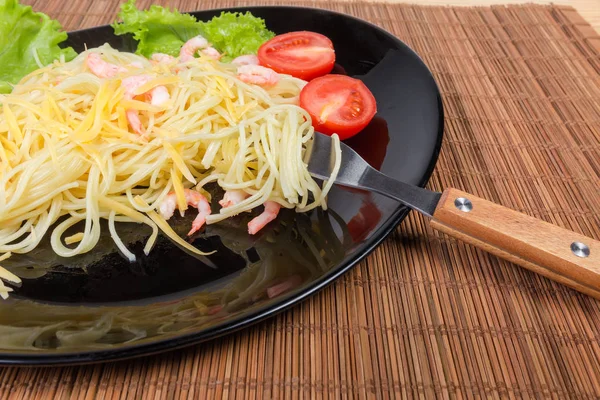 Spaghetti cotti con gamberetti, formaggio, pomodori, lattuga e forchetta — Foto Stock