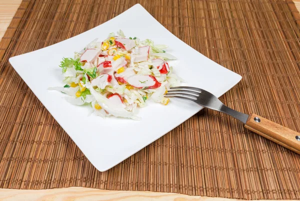 Σαλάτα του сrab μπαστούνια, λάχανο napa στο πιάτο με πιρούνι — Φωτογραφία Αρχείου