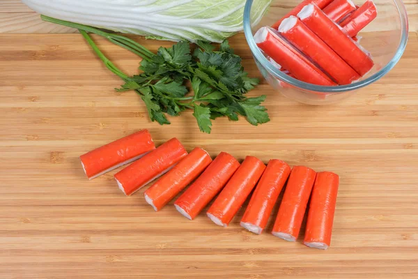 Palitos de cangrejo rellenos en la tabla de cortar contra de verduras — Foto de Stock