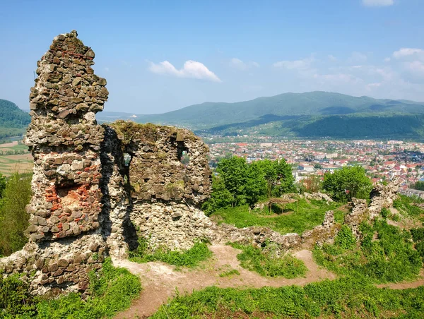 Antiguas ruinas de la fortaleza Khust en el fondo de la ciudad y los Cárpatos —  Fotos de Stock