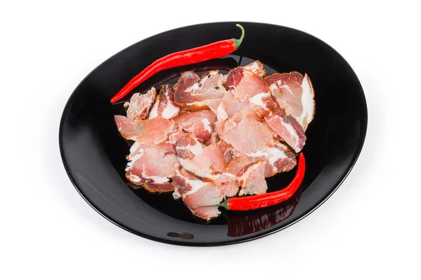 豚首肉と黒皿に唐辛子の薄切り — ストック写真