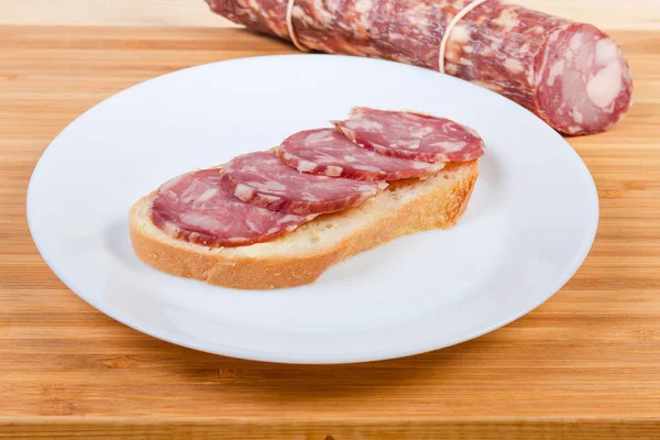 Open sandwich with dry-cured sausage and not sliced sausage — Stock Photo, Image