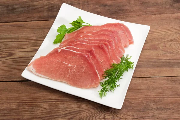 吉濱未調理の豚肉スライス、正方形の皿の上の野菜添え — ストック写真
