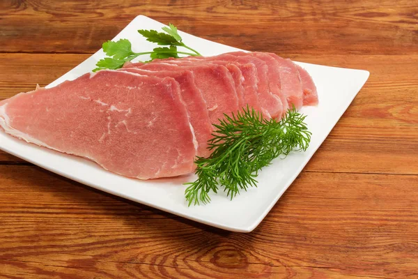 Fatias de porco descongeladas não cozidas com verduras no prato quadrado — Fotografia de Stock
