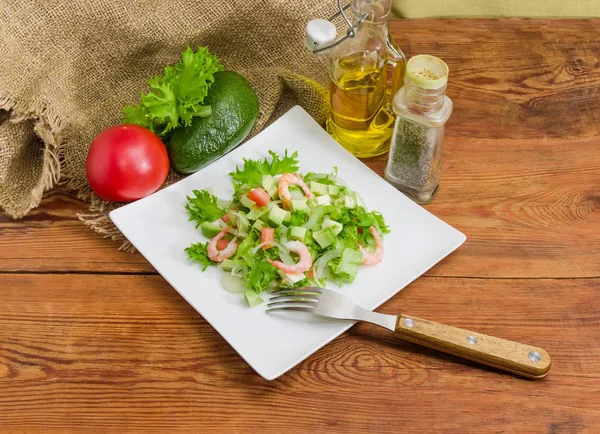 Salada de abacate em prato quadrado com garfo e alguns ingredientes — Fotografia de Stock