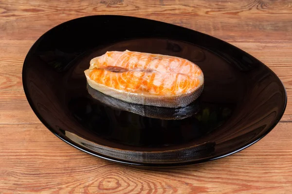 Жареный стейк арктической чары на черной тарелке крупным планом — стоковое фото