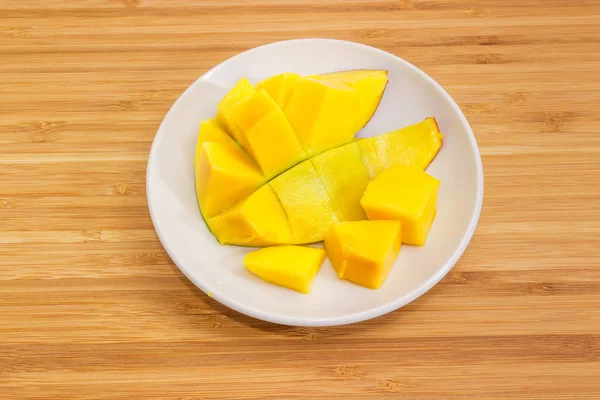 Mitad de mango preparado en platillo sobre una superficie de madera —  Fotos de Stock