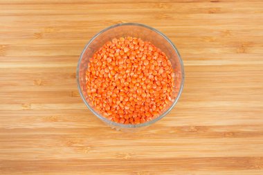 Ahşap yüzeyüzerinde cam dolusu bölünmüş kırmızı mercimek üst görünümü 