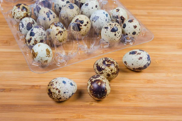 Wachteleier gegen Verpackung derselben Eier aus nächster Nähe — Stockfoto