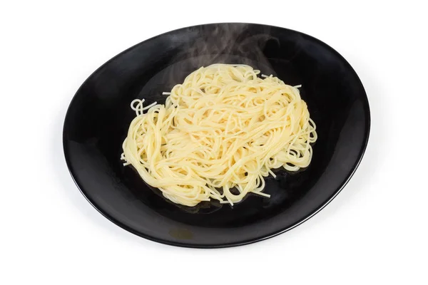 Spaghetti cotti su piatto nero su fondo bianco — Foto Stock