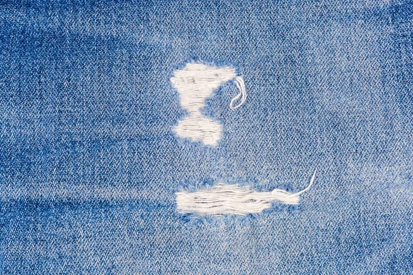 Endroits frottés sur un jean bleu avec des fils effilochés close-up — Photo
