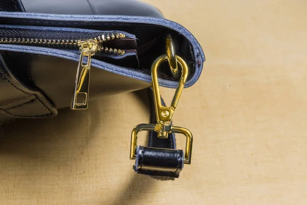 Fragmento de bolsa preta com alguns acessórios de saco de metal amarelo — Fotografia de Stock