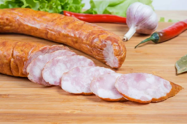 Saucisse de bologne partiellement tranchée parmi certaines épices close-up — Photo