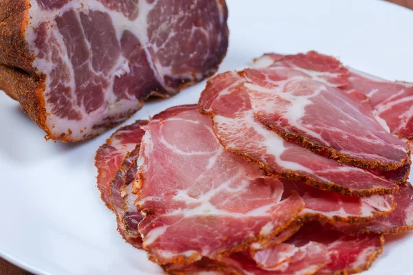 Partly sliced dried pork neck close-up at selective focus — Stock Photo, Image