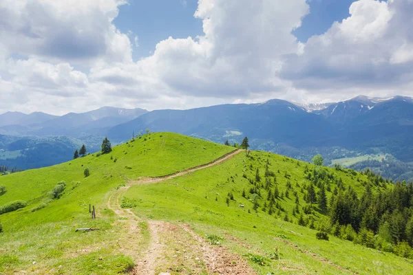 Cresta de montaña sin árboles con camino de tierra contra montañas distantes —  Fotos de Stock